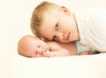 Two children on bed, eldest brother hugging youngest baby Royalty Free Stock Photo