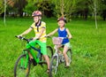 Two children on bicycles in a field of grass