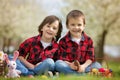 Two children, boy brothers, eating chocolate bunnies and having Royalty Free Stock Photo