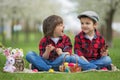 Two children, boy brothers, eating chocolate bunnies and having Royalty Free Stock Photo