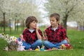 Two children, boy brothers, eating chocolate bunnies and having Royalty Free Stock Photo