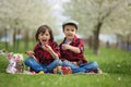 Two children, boy brothers, eating chocolate bunnies and having Royalty Free Stock Photo