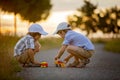 Two children, boy brothers, having fun outdoors with toy cars Royalty Free Stock Photo