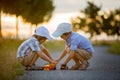 Two children, boy brothers, having fun outdoors with toy cars Royalty Free Stock Photo