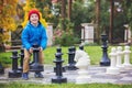 Two children, boy brothers, playing chess with huge figures in t Royalty Free Stock Photo