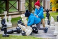 Two children, boy brothers, playing chess with huge figures in t Royalty Free Stock Photo