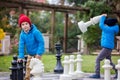 Two children, boy brothers, playing chess with huge figures in t Royalty Free Stock Photo