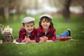 Two children, boy brothers, reading a book and eating strawberries in the park Royalty Free Stock Photo