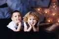 Two children, boy and girl, brother and sister, siblings, laying in bed in loft styled bedroom with star on background. Curly Royalty Free Stock Photo