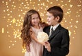 Two children boy and girl are in christmas lights, yellow background, winter holiday concept Royalty Free Stock Photo