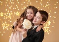 Two children boy and girl are in christmas lights, yellow background, winter holiday concept Royalty Free Stock Photo