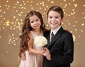 Two children boy and girl are in christmas lights, yellow background, winter holiday concept Royalty Free Stock Photo