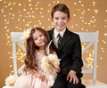 Two children boy and girl are in christmas lights, yellow background, winter holiday concept Royalty Free Stock Photo