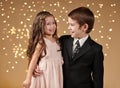 Two children boy and girl are in christmas lights, yellow background, winter holiday concept Royalty Free Stock Photo