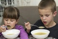 Two children boy and girl eating soup Royalty Free Stock Photo