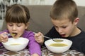 Two children boy and girl eating soup Royalty Free Stock Photo