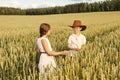 Two children boy and girl examine ears of corn on a wheat field Royalty Free Stock Photo