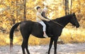 Two children boy and girl riding on horse in autumn Royalty Free Stock Photo