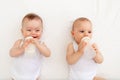 Two children a boy and a girl-twins of 8 months drink milk from a bottle on the bed in the nursery, feeding the baby, baby food Royalty Free Stock Photo