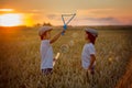 Two children, boys, chasing soap bubbles in a wheat field on sun Royalty Free Stock Photo