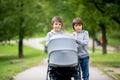 Two children, boys, pushing stroller with little baby Royalty Free Stock Photo