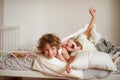 Two children, brother and sister, indulge on the bed in the bedroom.