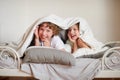 Two children, brother and sister, squirmy on the bed in the bedroom.