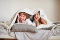 Two children, brother and sister, squirmy on the bed in the bedroom.