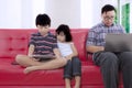 Two children with busy father at home
