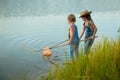 Two children with a butterfly net near the river