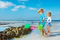 Two children with butterfly net on the sand beach catching crabs Royalty Free Stock Photo