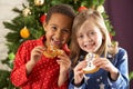 Two Children Eating Treats In Front Of Tree Royalty Free Stock Photo