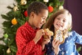 Two Children Eating Treats In Front Of Tree Royalty Free Stock Photo