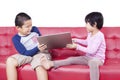 Two children fighting over a laptop