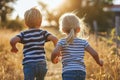 Two children friends cousins running through wheat field joy freedom in nature summer spring happiness childhood games