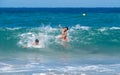 two teenagers have fun on the beach playing with big waves Royalty Free Stock Photo