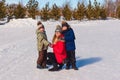 two children hug smiling mother in the snow in the winter. Happy family. people in outer clothing Royalty Free Stock Photo