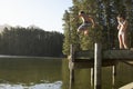 Two Children Jumping From Jetty Into Lake Royalty Free Stock Photo