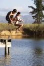 Two Children Jumping From Jetty Into Lake Royalty Free Stock Photo