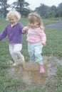 Two children jumping over a puddle, Washington D.C.