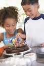 Two children in kitchen with birthday cake Royalty Free Stock Photo