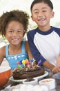 Two children in kitchen with birthday cake Royalty Free Stock Photo