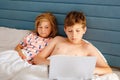 Two children, little girl and school boy learn online at home. Kids, siblings using laptop for homeschooling and Royalty Free Stock Photo