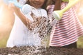 Two children little girl watering dry tree with watering pot