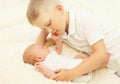 Two children lying on the bed, eldest brother hugging youngest