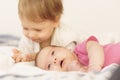 Two children lying on the bed hugging indoors.Older brother laying down ,cuddling ,hugging and holding the hand of his Royalty Free Stock Photo