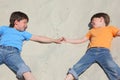 Two children lying nearby on sand Royalty Free Stock Photo