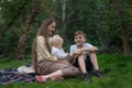 Two children and mom enjoying picnic in summer. Happy family resting in the Park Royalty Free Stock Photo