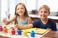 Two Children Painting Picture At Home