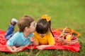 Two children on a picnic. a boy in a blue T-shirt kisses a girl in the yellow sweater on the head